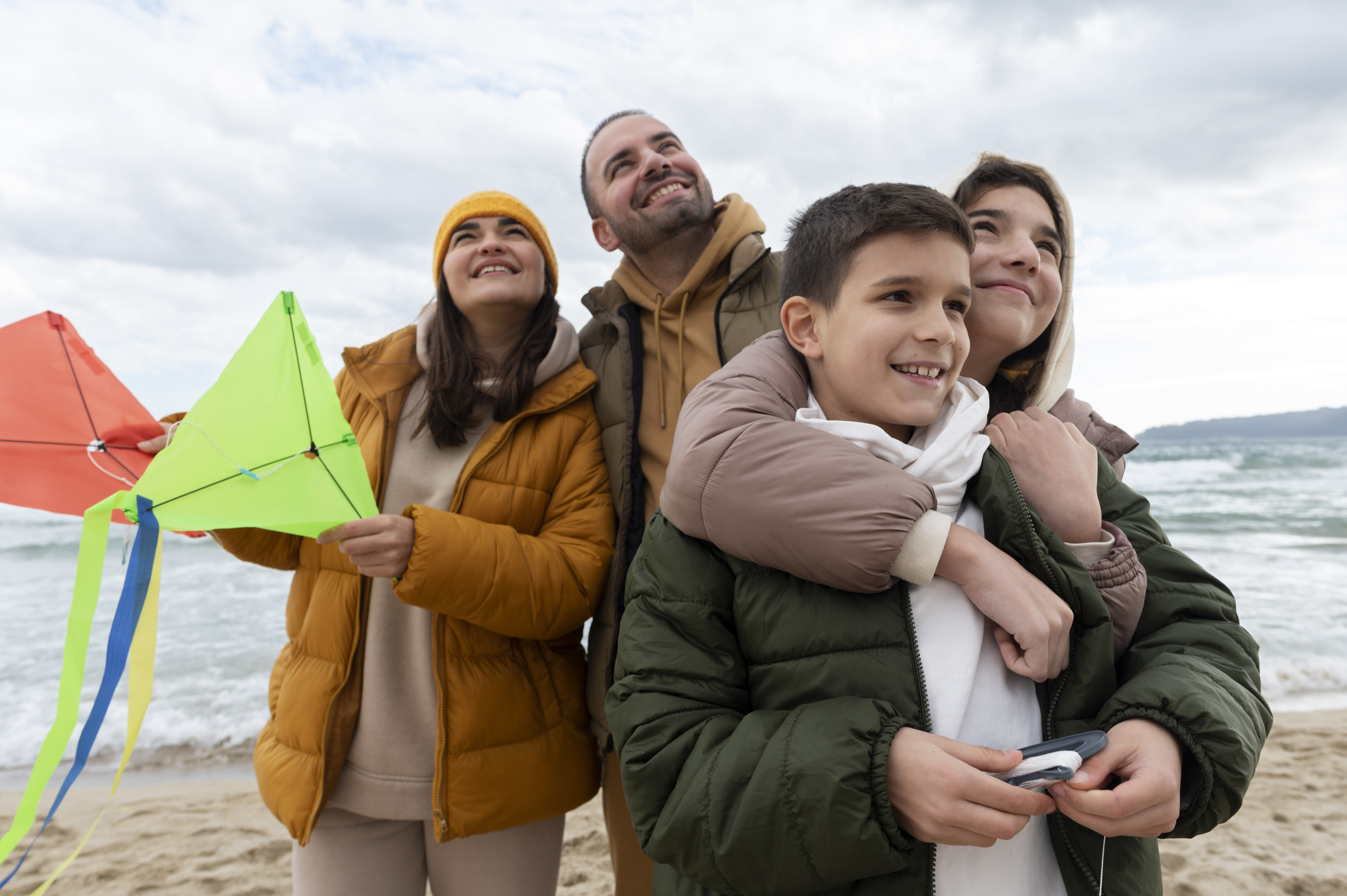 familia en la playa con cometas de colores